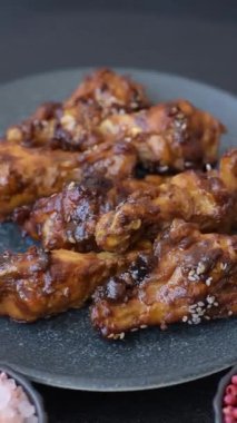 Izgara ya da ızgara tavuk kanadı, teriyaki sosu, baharat ve susam tohumuyla. Koyu arkaplanda tuz ve baharatlı Teriyaki tavuğu