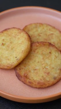 Mücver, patates, soğan ve sebzeden yapılmış kahvaltı yemeği. Koyu beton arka planda patates, tuz ve baharatlı mücver.