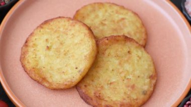 Mücver, patates, soğan ve sebzeden yapılmış kahvaltı yemeği. Koyu beton arka planda patates, tuz ve baharatlı mücver.