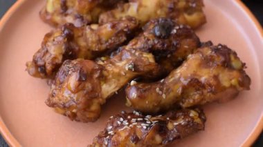 Izgara ya da ızgara tavuk kanadı, teriyaki sosu, baharat ve susam tohumuyla. Koyu arkaplanda tuz ve baharatlı Teriyaki tavuğu