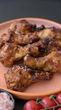 Izgara ya da ızgara tavuk kanadı, teriyaki sosu, baharat ve susam tohumuyla. Koyu arkaplanda tuz ve baharatlı Teriyaki tavuğu