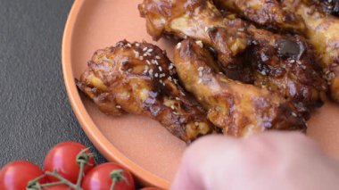 Izgara ya da ızgara tavuk kanadı, teriyaki sosu, baharat ve susam tohumuyla. Koyu arkaplanda tuz ve baharatlı Teriyaki tavuğu