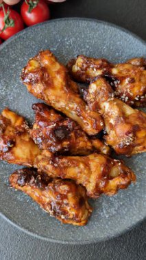 Izgara ya da ızgara tavuk kanadı, teriyaki sosu, baharat ve susam tohumuyla. Koyu arkaplanda tuz ve baharatlı Teriyaki tavuğu
