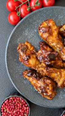 Izgara ya da ızgara tavuk kanadı, teriyaki sosu, baharat ve susam tohumuyla. Koyu arkaplanda tuz ve baharatlı Teriyaki tavuğu