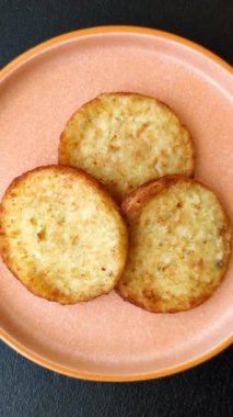 Mücver, patates, soğan ve sebzeden yapılmış kahvaltı yemeği. Koyu beton arka planda patates, tuz ve baharatlı mücver.