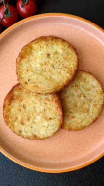 Mücver, patates, soğan ve sebzeden yapılmış kahvaltı yemeği. Koyu beton arka planda patates, tuz ve baharatlı mücver.