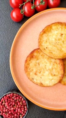 Mücver, patates, soğan ve sebzeden yapılmış kahvaltı yemeği. Koyu beton arka planda patates, tuz ve baharatlı mücver.