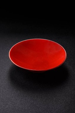 Yemek için boş yuvarlak siyah tabak, yemek masasında mutfak gereçleri. Koyu arkaplanda boş tabak