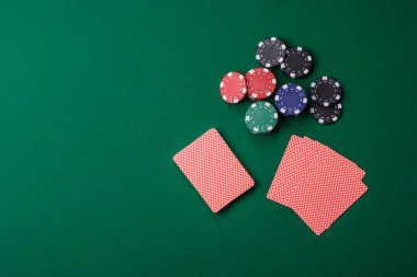 Kumarhanede poker oynuyorum. Fişler, bahisler ve risklerle. Yeşil kartlar ve çipler tasarımınız için arka plan görevi görür