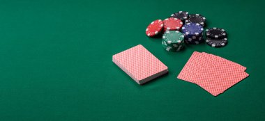 Kumarhanede poker oynuyorum. Fişler, bahisler ve risklerle. Yeşil kartlar ve çipler tasarımınız için arka plan görevi görür