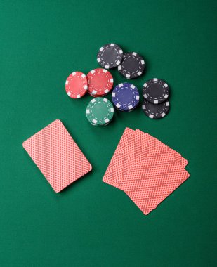 Kumarhanede poker oynuyorum. Fişler, bahisler ve risklerle. Yeşil kartlar ve çipler tasarımınız için arka plan görevi görür