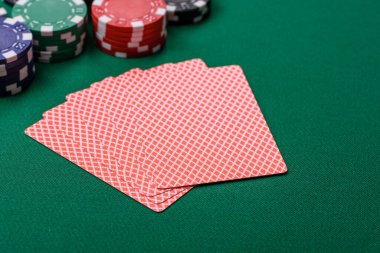 Kumarhanede poker oynuyorum. Fişler, bahisler ve risklerle. Yeşil kartlar ve çipler tasarımınız için arka plan görevi görür