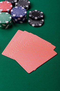 Kumarhanede poker oynuyorum. Fişler, bahisler ve risklerle. Yeşil kartlar ve çipler tasarımınız için arka plan görevi görür