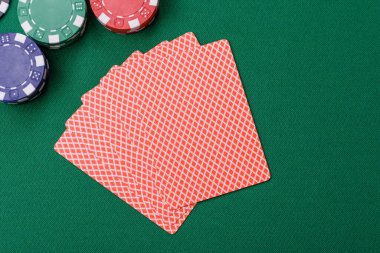 Kumarhanede poker oynuyorum. Fişler, bahisler ve risklerle. Yeşil kartlar ve çipler tasarımınız için arka plan görevi görür