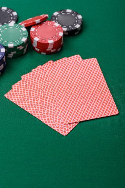 Kumarhanede poker oynuyorum. Fişler, bahisler ve risklerle. Yeşil kartlar ve çipler tasarımınız için arka plan görevi görür