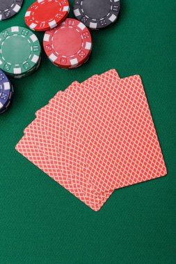 Kumarhanede poker oynuyorum. Fişler, bahisler ve risklerle. Yeşil kartlar ve çipler tasarımınız için arka plan görevi görür