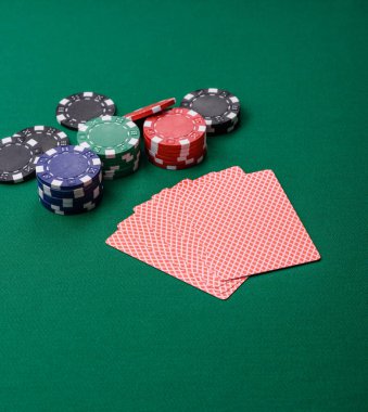 Kumarhanede poker oynuyorum. Fişler, bahisler ve risklerle. Yeşil kartlar ve çipler tasarımınız için arka plan görevi görür