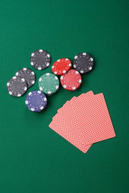 Kumarhanede poker oynuyorum. Fişler, bahisler ve risklerle. Yeşil kartlar ve çipler tasarımınız için arka plan görevi görür