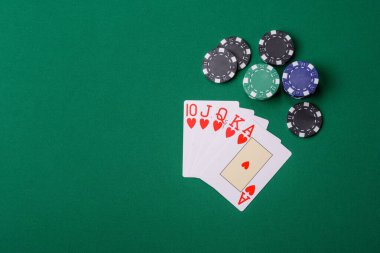 Kumarhanede poker oynuyorum. Fişler, bahisler ve risklerle. Yeşil kartlar ve çipler tasarımınız için arka plan görevi görür