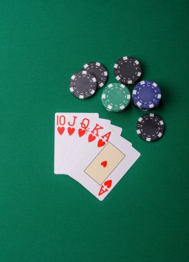 Kumarhanede poker oynuyorum. Fişler, bahisler ve risklerle. Yeşil kartlar ve çipler tasarımınız için arka plan görevi görür