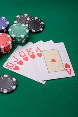 Kumarhanede poker oynuyorum. Fişler, bahisler ve risklerle. Yeşil kartlar ve çipler tasarımınız için arka plan görevi görür