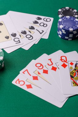 Kumarhanede poker oynuyorum. Fişler, bahisler ve risklerle. Yeşil kartlar ve çipler tasarımınız için arka plan görevi görür