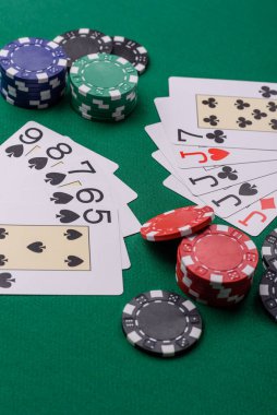 Kumarhanede poker oynuyorum. Fişler, bahisler ve risklerle. Yeşil kartlar ve çipler tasarımınız için arka plan görevi görür