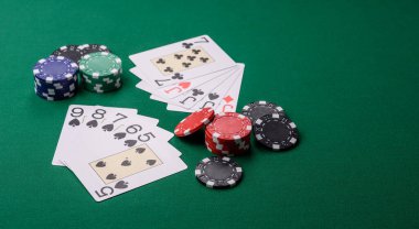 Kumarhanede poker oynuyorum. Fişler, bahisler ve risklerle. Yeşil kartlar ve çipler tasarımınız için arka plan görevi görür