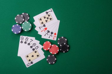 Kumarhanede poker oynuyorum. Fişler, bahisler ve risklerle. Yeşil kartlar ve çipler tasarımınız için arka plan görevi görür