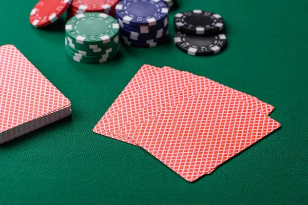 Kumarhanede poker oynuyorum. Fişler, bahisler ve risklerle. Yeşil kartlar ve çipler tasarımınız için arka plan görevi görür