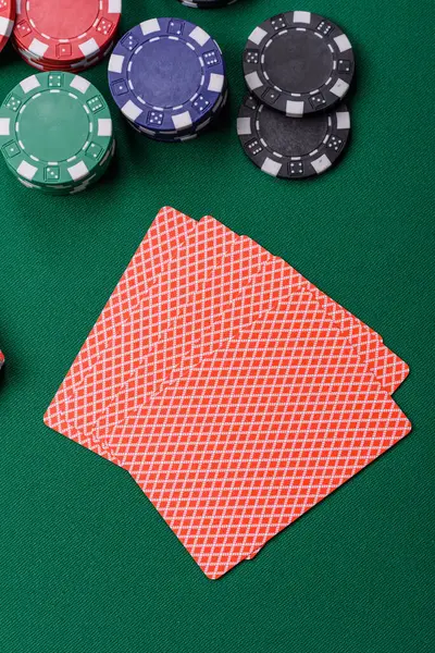 Kumarhanede poker oynuyorum. Fişler, bahisler ve risklerle. Yeşil kartlar ve çipler tasarımınız için arka plan görevi görür