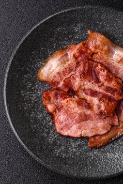 Lezzetli bir İngiliz kahvaltısının malzemesi olarak kızarmış domuz pastırması. Tasarımın için arka plan olarak kızarmış pastırma parçaları.