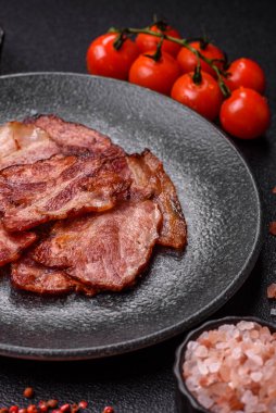 Lezzetli bir İngiliz kahvaltısının malzemesi olarak kızarmış domuz pastırması. Tasarımın için arka plan olarak kızarmış pastırma parçaları.