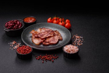 Lezzetli bir İngiliz kahvaltısının malzemesi olarak kızarmış domuz pastırması. Tasarımın için arka plan olarak kızarmış pastırma parçaları.