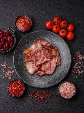 Lezzetli bir İngiliz kahvaltısının malzemesi olarak kızarmış domuz pastırması. Tasarımın için arka plan olarak kızarmış pastırma parçaları.