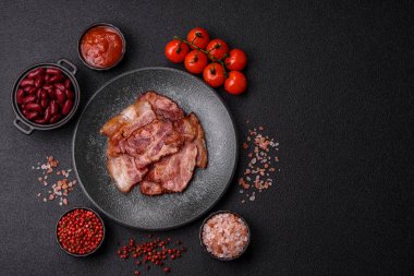 Lezzetli bir İngiliz kahvaltısının malzemesi olarak kızarmış domuz pastırması. Tasarımın için arka plan olarak kızarmış pastırma parçaları.