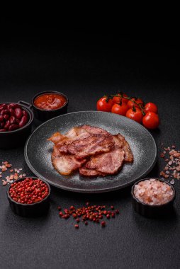 Lezzetli bir İngiliz kahvaltısının malzemesi olarak kızarmış domuz pastırması. Tasarımın için arka plan olarak kızarmış pastırma parçaları.