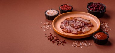 Lezzetli bir İngiliz kahvaltısının malzemesi olarak kızarmış domuz pastırması. Tasarımın için arka plan olarak kızarmış pastırma parçaları.