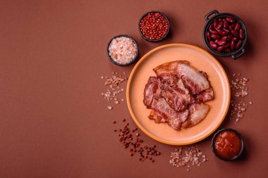 Lezzetli bir İngiliz kahvaltısının malzemesi olarak kızarmış domuz pastırması. Tasarımın için arka plan olarak kızarmış pastırma parçaları.