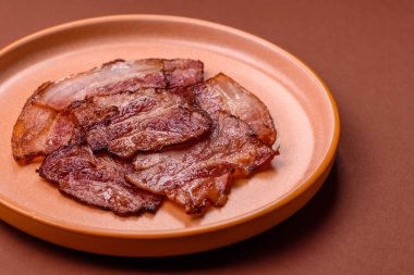 Lezzetli bir İngiliz kahvaltısının malzemesi olarak kızarmış domuz pastırması. Tasarımın için arka plan olarak kızarmış pastırma parçaları.