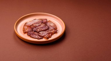 Lezzetli bir İngiliz kahvaltısının malzemesi olarak kızarmış domuz pastırması. Tasarımın için arka plan olarak kızarmış pastırma parçaları.