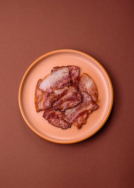 Lezzetli bir İngiliz kahvaltısının malzemesi olarak kızarmış domuz pastırması. Tasarımın için arka plan olarak kızarmış pastırma parçaları.
