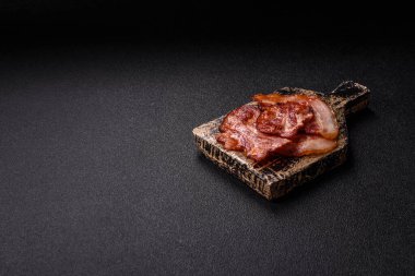 Lezzetli bir İngiliz kahvaltısının malzemesi olarak kızarmış domuz pastırması. Tasarımın için arka plan olarak kızarmış pastırma parçaları.