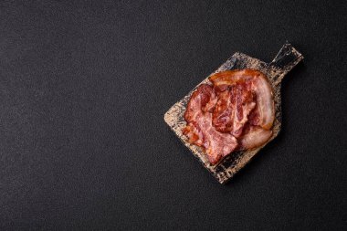 Lezzetli bir İngiliz kahvaltısının malzemesi olarak kızarmış domuz pastırması. Tasarımın için arka plan olarak kızarmış pastırma parçaları.