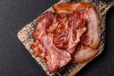 Lezzetli bir İngiliz kahvaltısının malzemesi olarak kızarmış domuz pastırması. Tasarımın için arka plan olarak kızarmış pastırma parçaları.