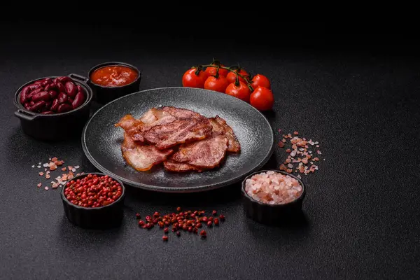 Lezzetli bir İngiliz kahvaltısının malzemesi olarak kızarmış domuz pastırması. Tasarımın için arka plan olarak kızarmış pastırma parçaları.