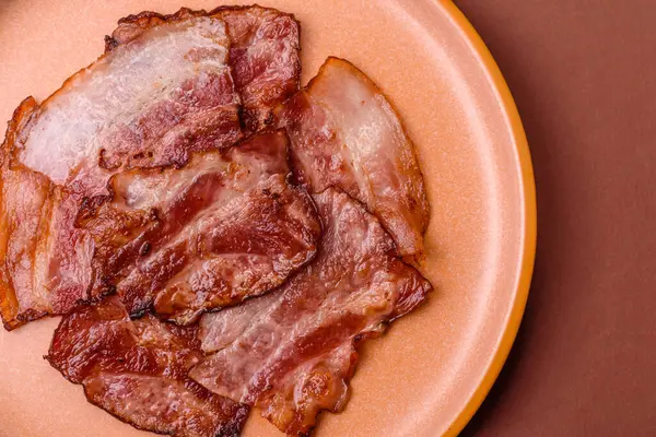 Lezzetli bir İngiliz kahvaltısının malzemesi olarak kızarmış domuz pastırması. Tasarımın için arka plan olarak kızarmış pastırma parçaları.