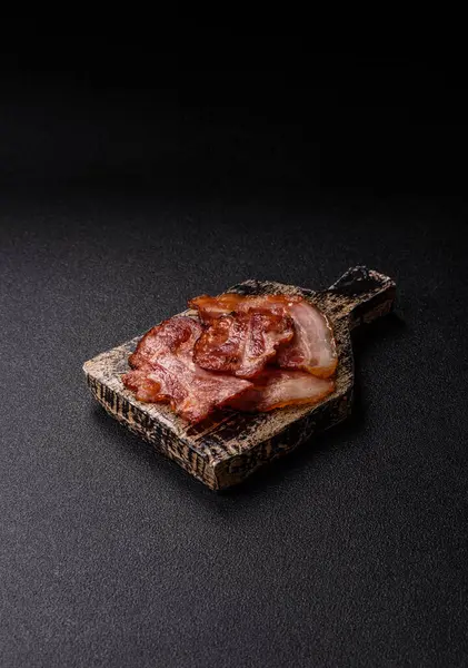 Lezzetli bir İngiliz kahvaltısının malzemesi olarak kızarmış domuz pastırması. Tasarımın için arka plan olarak kızarmış pastırma parçaları.