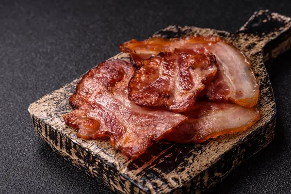 Lezzetli bir İngiliz kahvaltısının malzemesi olarak kızarmış domuz pastırması. Tasarımın için arka plan olarak kızarmış pastırma parçaları.