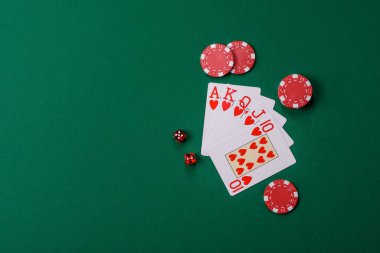 Kumarhanede poker oynuyorum. Fişler, bahisler ve risklerle. Yeşil kartlar ve çipler tasarımınız için arka plan görevi görür
